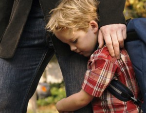 Son clinging to father's leg